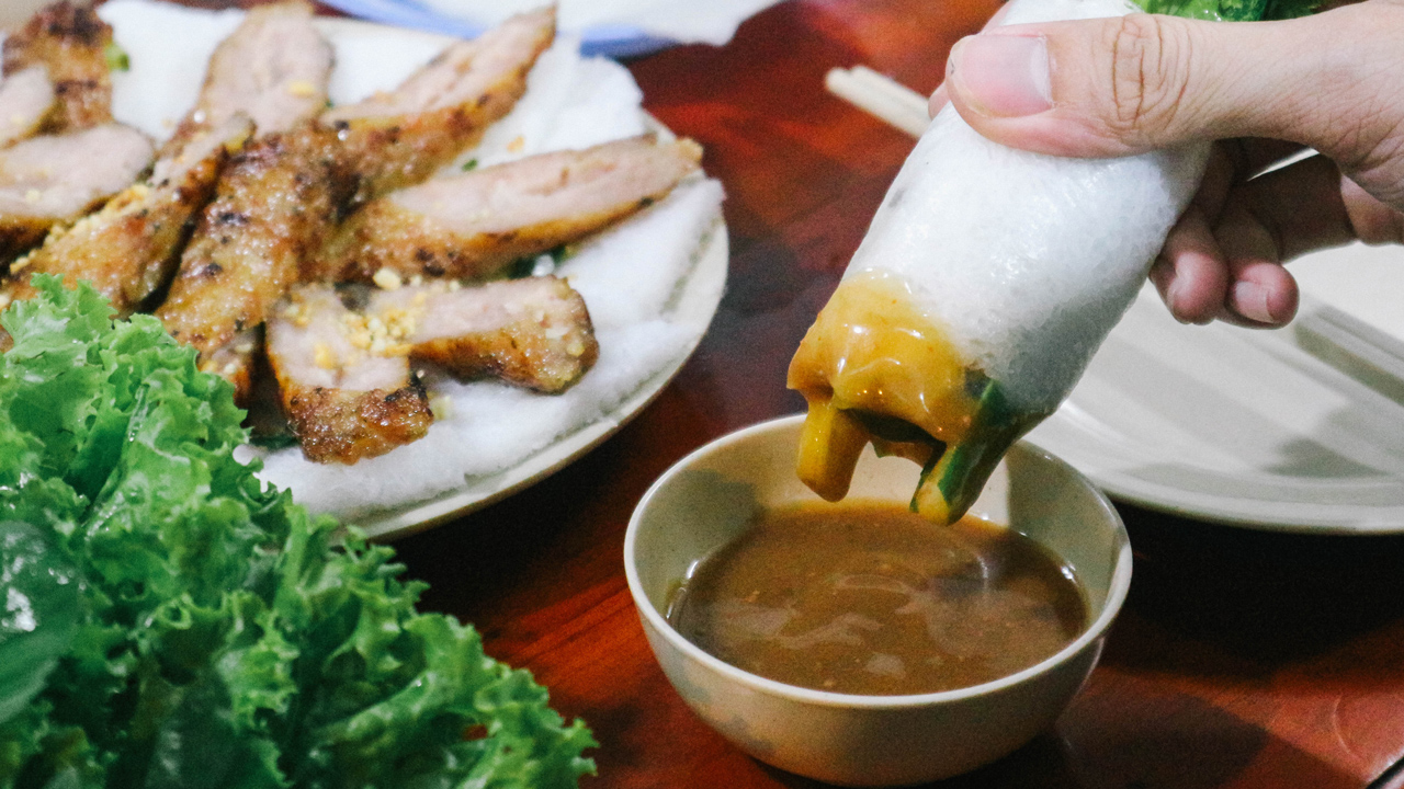 Dipping the pork BBQ roll in Vietnamese saurce
