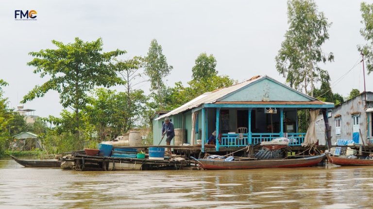 A man and woman living on their floating house surrounded by motorboats
