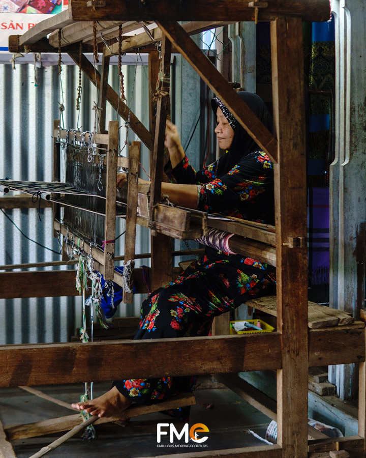 An elderly woman weaving with a loom