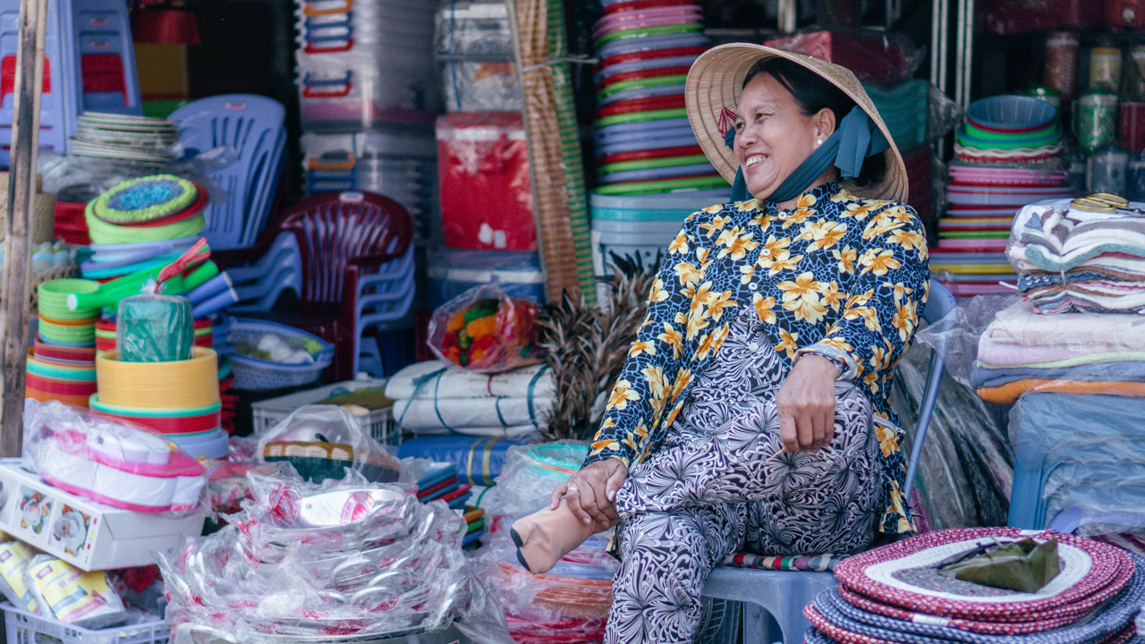 Smiling plastic household goods seller at the market