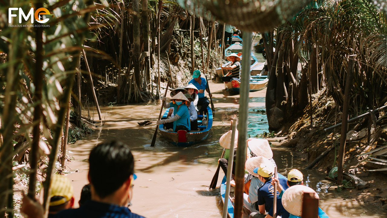 Groups of tourists are travelling by boats during their My Tho Ben Tre tour