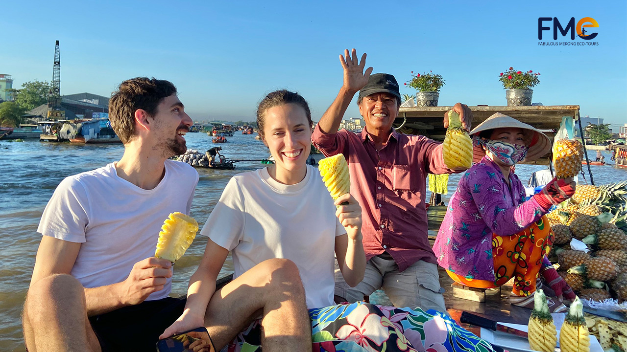 Tourists happily eating pineapple