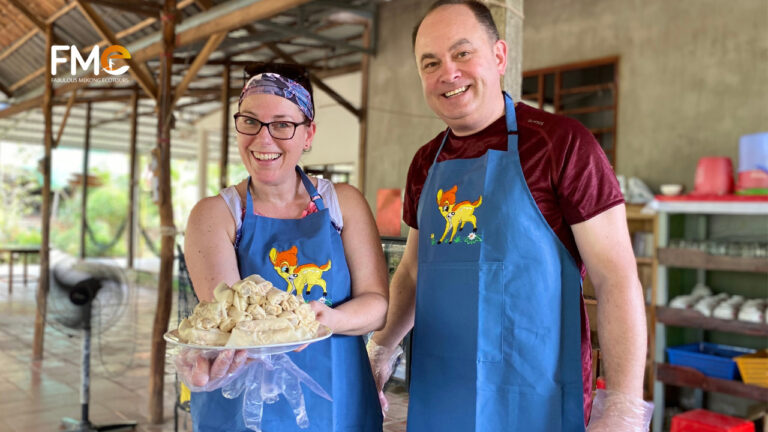 Tourists show the spring rolls that they've just made