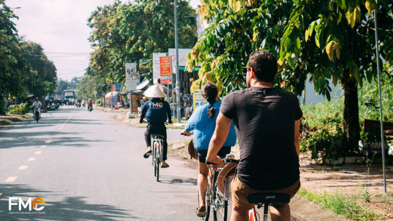 Tourists move through the streets of Can Tho on a cycling tour