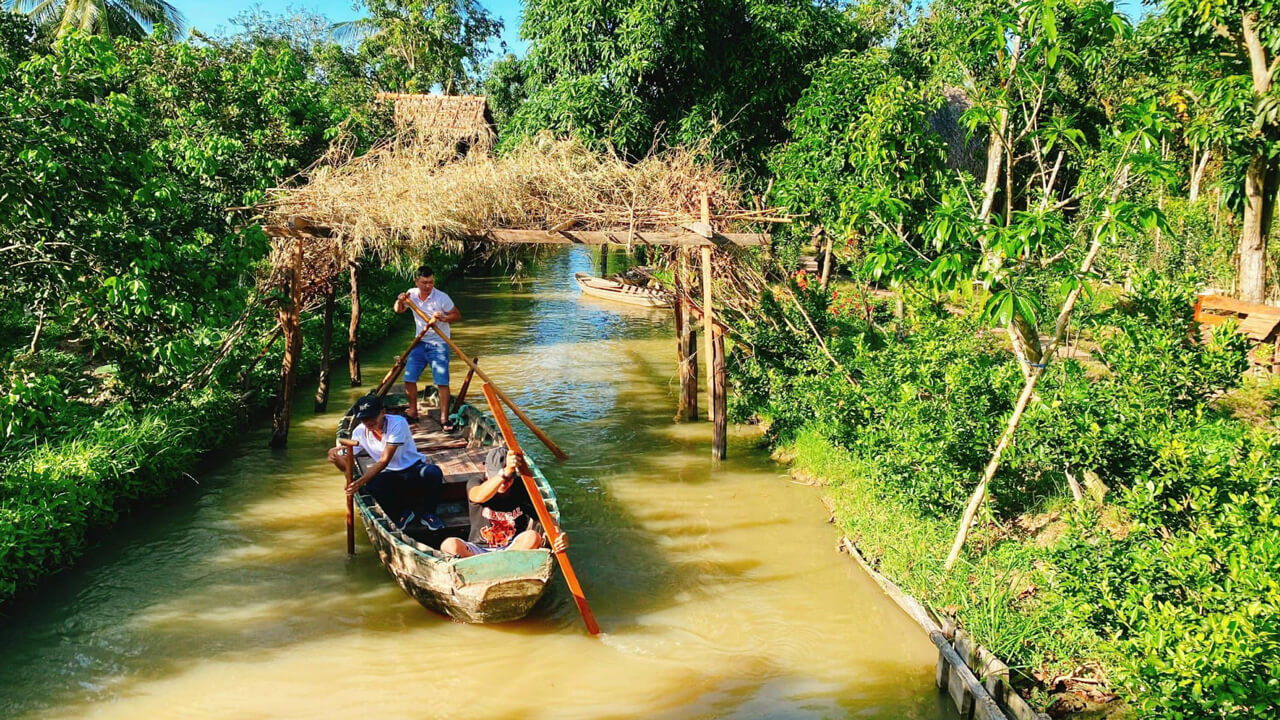 Tourists row boats around the fruit garden of Phi Yen eco-tourism area in Can Tho