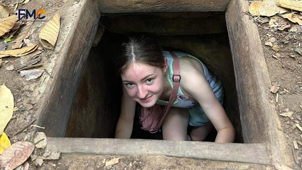 A tourist is entering the Cu Chi tunnels