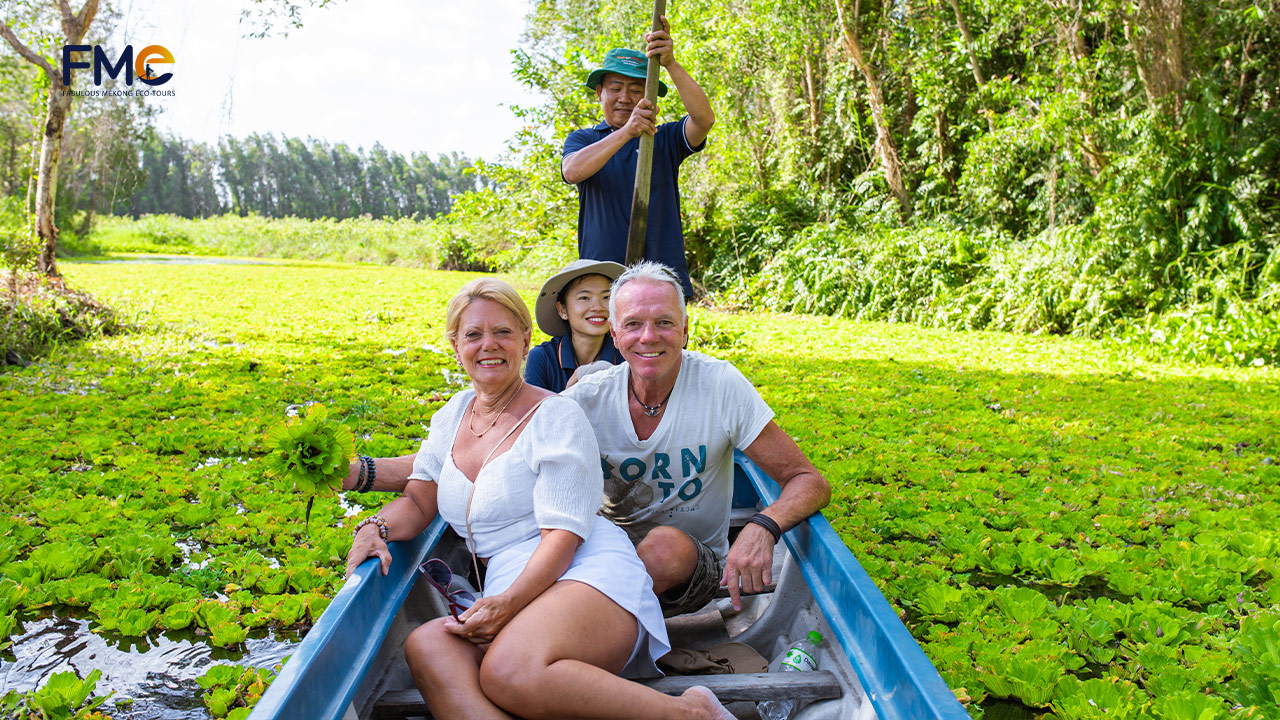 Tourists happily take photos while exploring the river full of duckweed