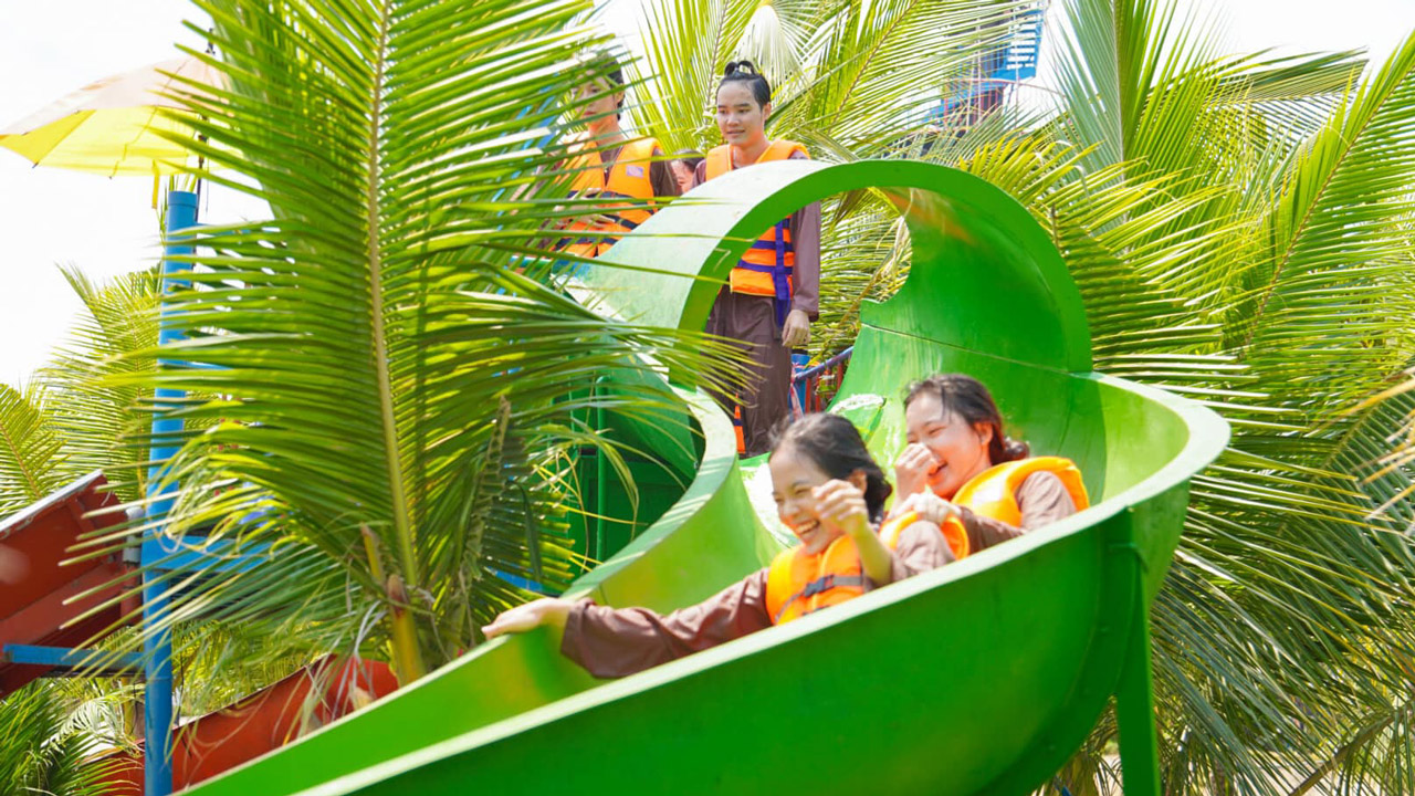 Tourists play on the slide at Con En Lugar eco-tourism area in An Giang