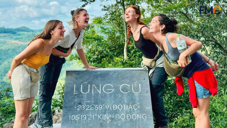 A joyful group of friends laughing and enjoying the moment near Lung Cu Flag Tower, the northernmost point of Vietnam