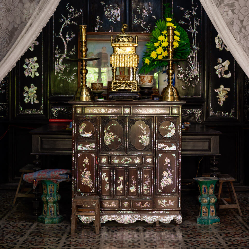 Close-up of ornate altar carvings and inlaid mother-of-pearl designs at Le Cong Ancestral House