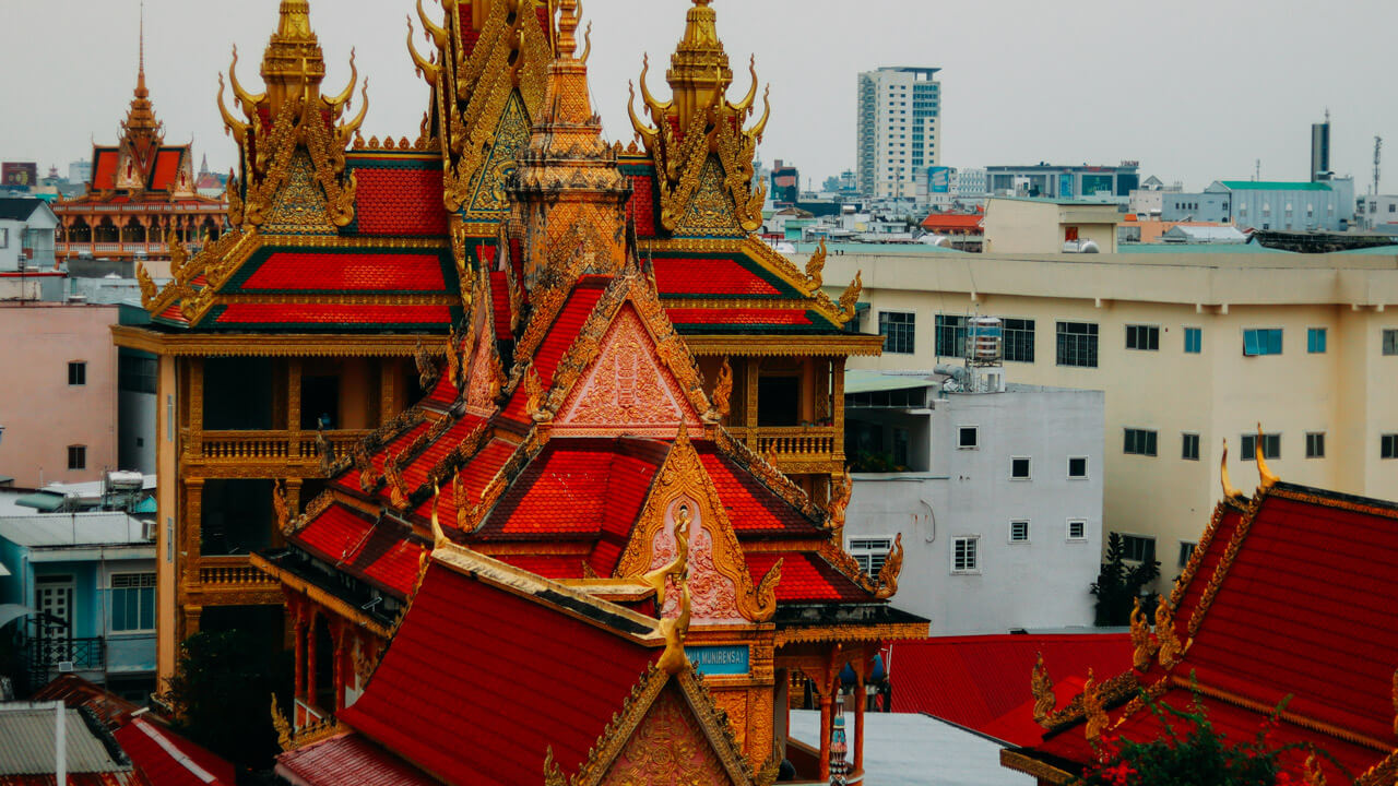 An aerial view of Pitu Khôsa Răngsây Temple amidst the urban landscape of Can Tho, capturing its architectural beauty