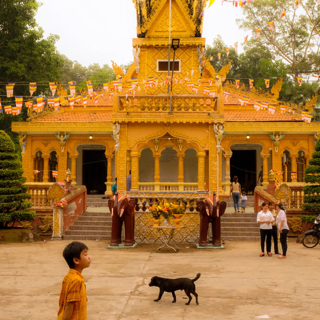 Front yard of a Buddhist temple in Vietnam during a festival, decorated with flags and offerings