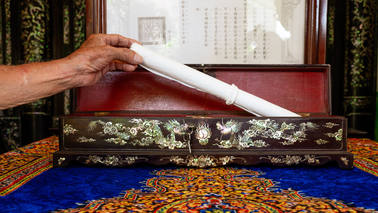 Ornate ceremonial box for scrolls in Le Cong Ancestral House, with intricate mother-of-pearl inlays