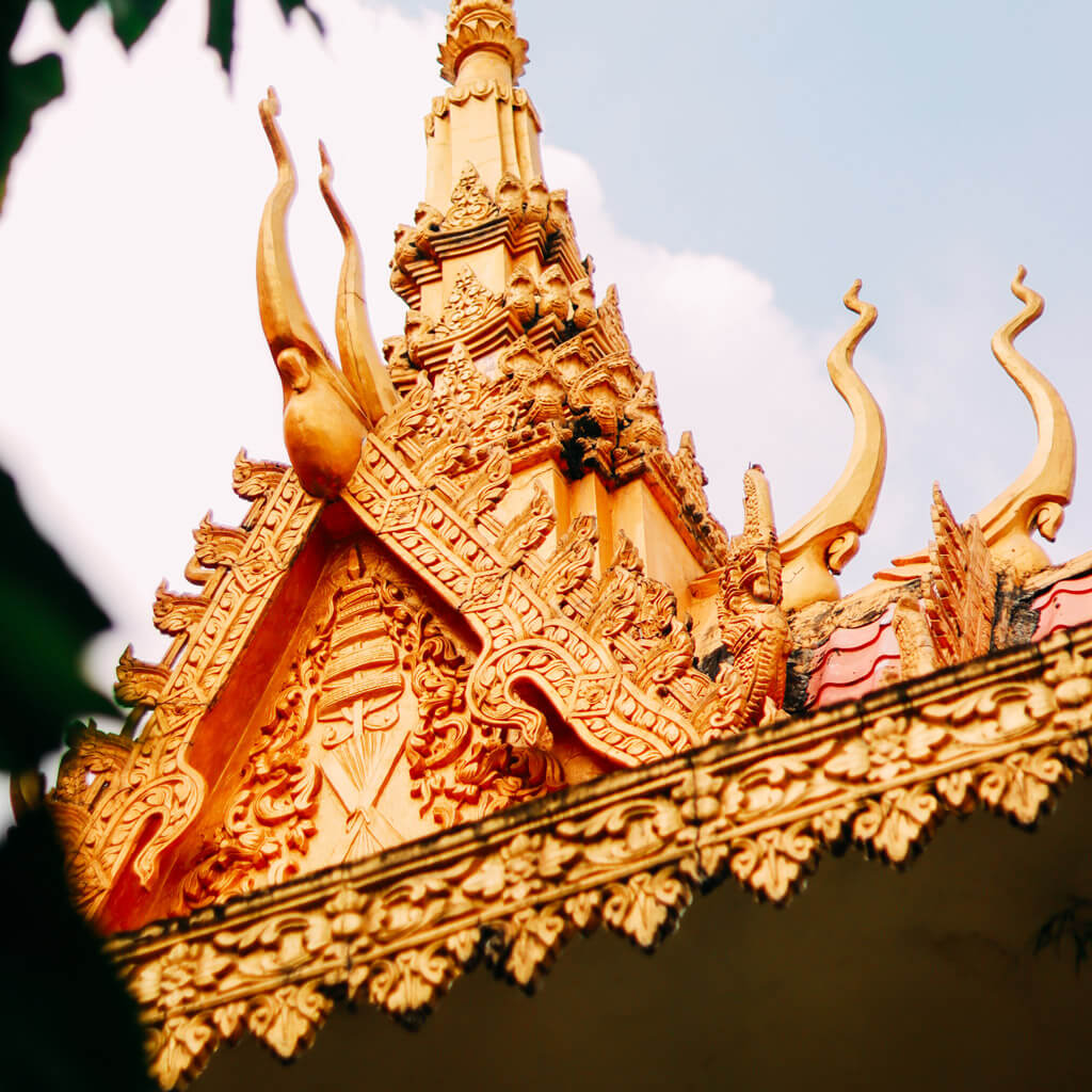 The golden roof adorned with Khmer motifs at Pitu Khôsa Răngsây Temple, glistening in the sunlight