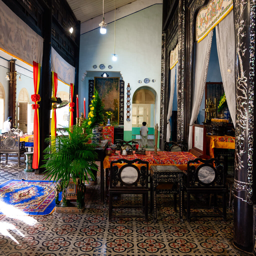 Interior view of Le Cong Ancestral House, featuring intricate wood carvings and antique furniture