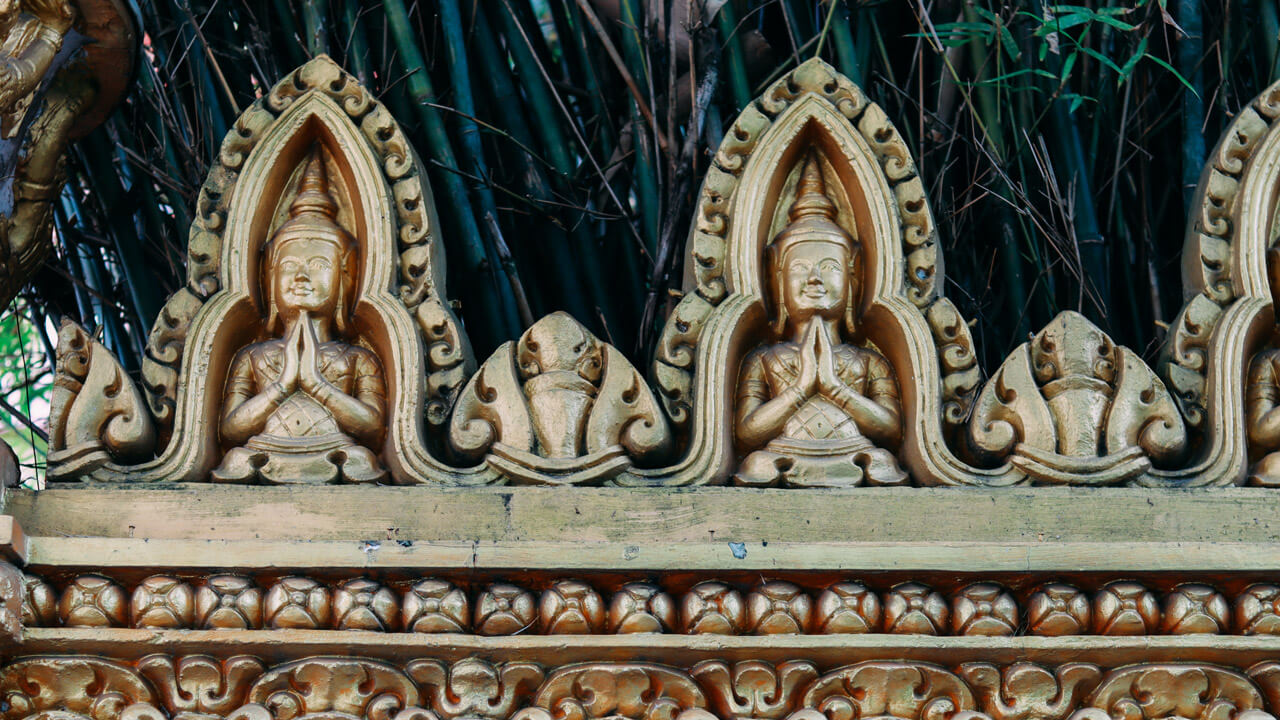 Delicate Khmer statues carved into the fence of Pitu Khôsa Răngsây Temple, illustrating cultural devotion