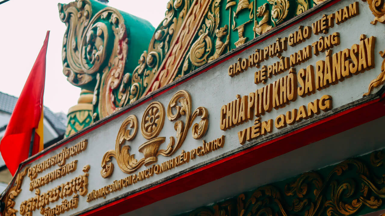 The entrance signage of Pitu Khôsa Răngsây Temple in Cần Thơ, showcasing Khmer and Vietnamese inscriptions