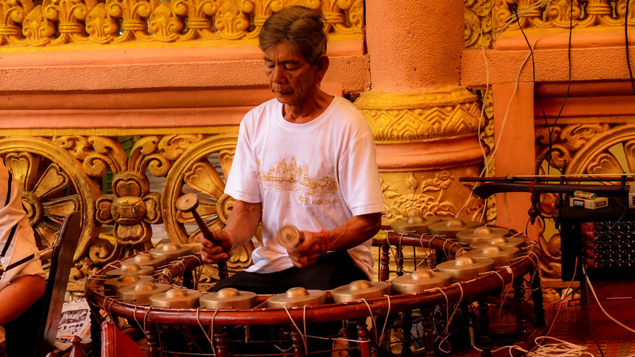 A musician playing traditional instruments during a ceremony at a Buddhist temple in Vietnam