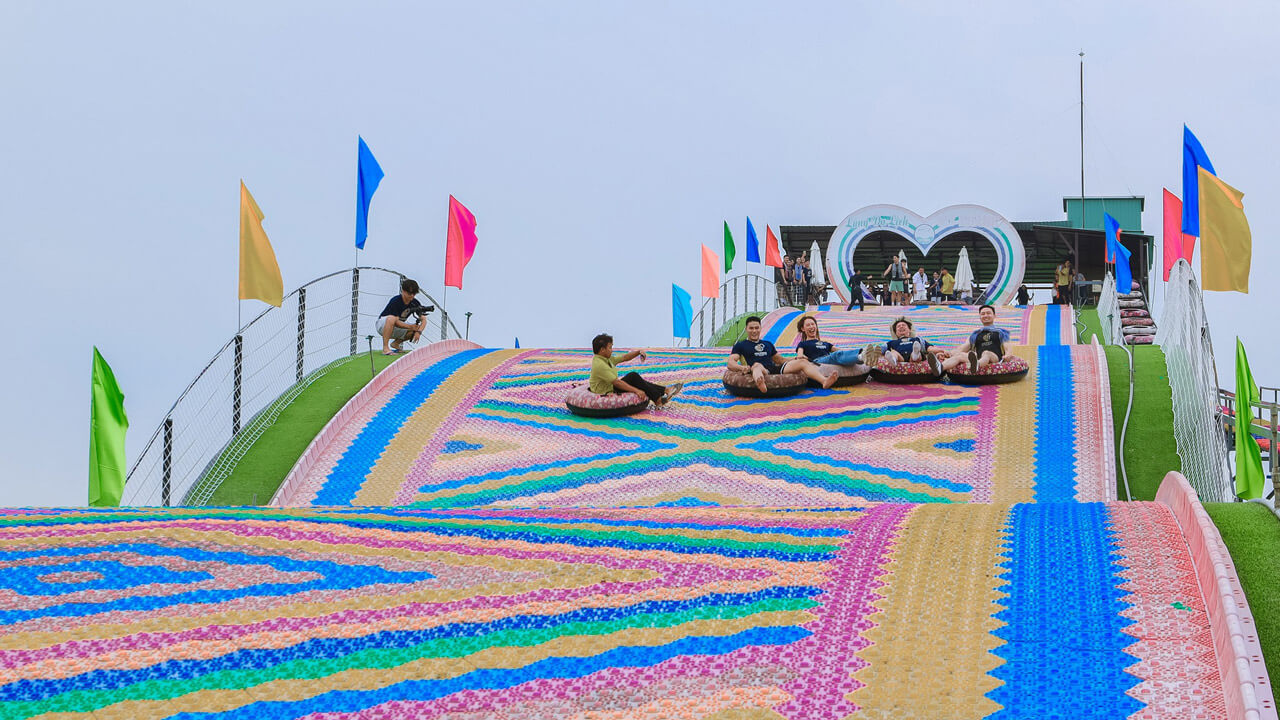 Visitors enjoying the colorful tube sliding activity at My Khanh Tourism Village, an exciting and picturesque spot for family fun in Can Tho