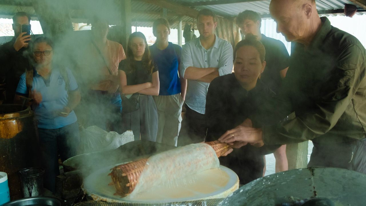 Learning how to make traditional rice noodles with local people during a field study in the Mekong Delta.