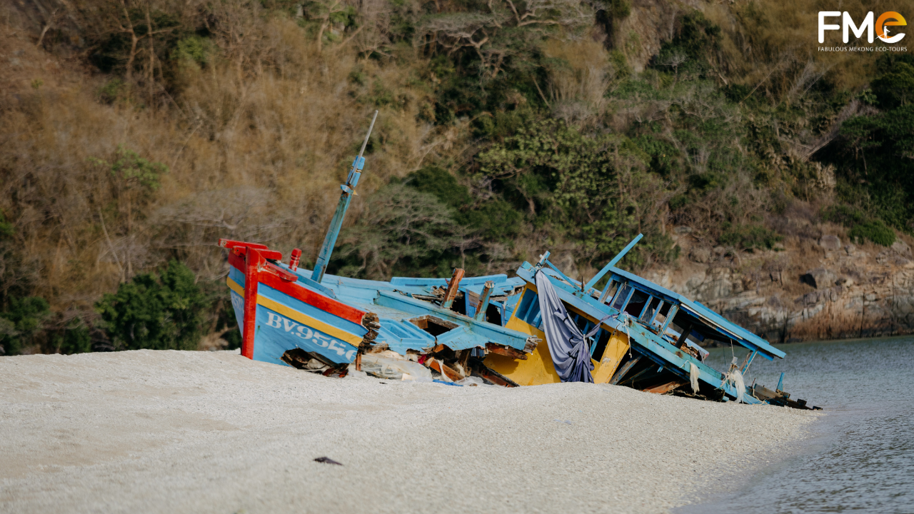 A rustic wooden shipwreck on a deserted beach in Con Dao, showcasing the raw and authentic beauty of untouched nature.