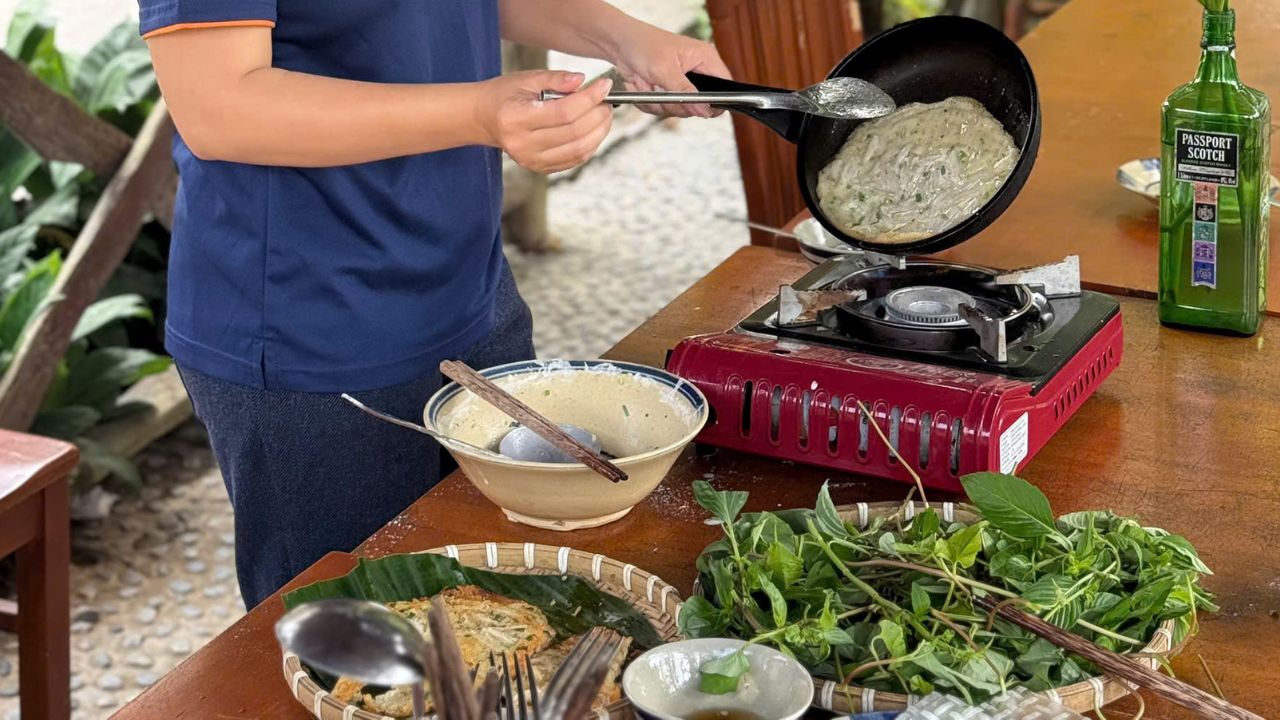 A member of FME Travel demonstrating the art of the golden crisp, pan-frying a Lonton batter cake until the edges turn golden brown.
